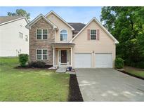 Charming two-story home boasts a stone facade, two-car garage, and well-manicured front yard at 237 River Pass Ct, Dacula, GA 30019