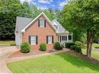 Charming two-story brick home featuring a well-manicured lawn and mature trees, located in a quiet neighborhood at 3040 Larkspur Ct, Cumming, GA 30041