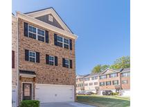 Charming brick townhome with an attached garage and dark shutters, offering a classic and inviting curb appeal at 3080 Westpoint Cir, Snellville, GA 30078