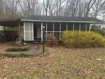 Charming single-story home with a screened-in porch and cozy carport, nestled among trees at 4201 Lindsey Dr, Decatur, GA 30035