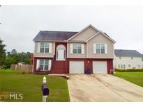 Charming two-story home features a well-manicured lawn, two car garage, and traditional architectural style at 95 Revere Dr, Fairburn, GA 30213