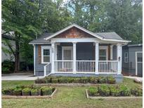 Charming cottage with front porch, white columns, and garden boxes ready for planting at 1100 Welch Sw St, Atlanta, GA 30310