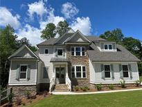 Beautiful two-story home with a stone and siding exterior, well-manicured lawn, and professional landscaping at 3730 Reserve Overlook (Lot 8) Way, Cumming, GA 30041