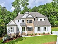 Beautiful two-story home with a stone and siding facade, landscaped front yard, and inviting entrance at 3730 Reserve Overlook (Lot 8) Way, Cumming, GA 30041