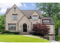 Charming brick home featuring manicured lawn, arched entry, and attached two-car garage at 1849 Rock Springs Ne Ln, Atlanta, GA 30324