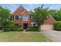 Charming two-story brick home with a well-manicured lawn and mature landscaping at 2154 Marne Nw Gln, Kennesaw, GA 30152