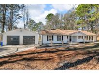Charming ranch-style home featuring a two-car garage and well-maintained front yard at 2401 Phillips Rd, Lithonia, GA 30058