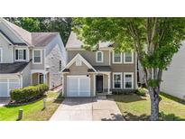 Charming two-story home with a well-manicured lawn and attached single car garage at 556 Poplar Bnd, Canton, GA 30114