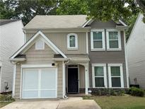 Charming two-story home with gray and beige siding, a garage, and a well-maintained lawn at 556 Poplar Bnd, Canton, GA 30114