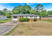 Charming single-story home featuring a well-maintained yard and a classic design with a cozy front porch at 2664 Olive Springs Se Rd, Marietta, GA 30060