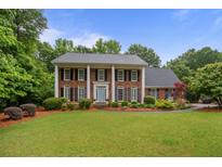 Beautiful two-story brick home with a well-manicured lawn and a charming blue front door at 3510 Smoke Rise Way, Lawrenceville, GA 30044