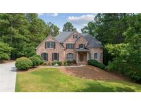 Charming brick home with a well-manicured lawn and lush landscaping at 5041 Corinault Nw Pl, Acworth, GA 30101