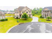 Charming two-story home with a well-manicured lawn, circular driveway and a view of the neighborhood pond at 6390 Yellow Birch St, Cumming, GA 30040