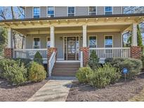 Charming home featuring a welcoming front porch with swing, brick accents, and beautiful landscaping at 2987 Jefferson St, Atlanta, GA 30341