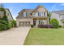 Charming two-story brick home featuring a well-manicured lawn, a two car garage, and inviting front porch at 3750 Sweeting St, Cumming, GA 30041