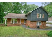 Charming split-level home featuring a brick facade, wood siding and a well-maintained front yard at 588 Benson Hurst Sw Dr, Mableton, GA 30126