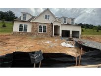 Charming two-story home with stone accents, dormer windows, and an attached two-car garage at 313 Willow Cv, Canton, GA 30114