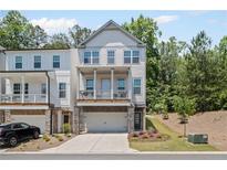 Two-story townhome showcases a private, covered porch and a two-car garage at 507 Bishop Ln, Woodstock, GA 30188