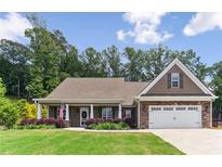 Charming home boasts a manicured lawn, inviting entrance, and a two-car garage, blending comfort with curb appeal at 59 Grand Georgian Ne Ct, Cartersville, GA 30121