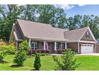 Charming single-story home features a well-manicured lawn, an attached garage, and a welcoming front porch at 59 Grand Georgian Ne Ct, Cartersville, GA 30121