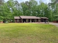 Charming single-story home featuring a well-manicured lawn and mature trees at 712 Honeysuckle Ln, Temple, GA 30179
