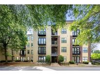 Beautiful condo exterior featuring a modern facade with balconies and lush green trees at 5300 Peachtree Rd # 105, Atlanta, GA 30341