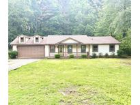 Charming single-story home with a well-maintained lawn and an attached two-car garage at 6832 Shangrila Way, Riverdale, GA 30296