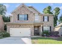 Charming brick two-story home with a well-maintained front yard and two car garage at 3300 Allison Cir, Decatur, GA 30034
