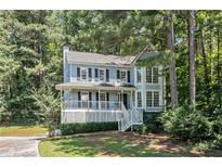 Charming two-story home boasts a covered porch and inviting curb appeal nestled amongst mature trees at 3 Maplelake Dr, Acworth, GA 30101
