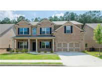 Charming two-story brick home with a well-manicured lawn, covered porch, and a two-car garage at 3405 Linstead Ct, Loganville, GA 30052