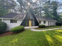 Charming home featuring A-frame design, white painted brick and a manicured front yard at 4274 Smithsonia Ct, Tucker, GA 30084