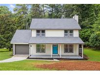 Charming two-story home with a welcoming front porch and a new gray roof, set amongst mature trees at 4657 Lou Ivy Rd, Peachtree Corners, GA 30096