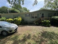 Charming home featuring a covered porch, well-maintained landscaping, and a welcoming facade at 6722 Heardsville Rd, Cumming, GA 30028