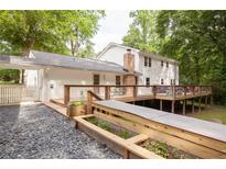 Expansive backyard view with large deck, stone path and flower beds in a lush, green setting at 5322 Seaton Dr, Atlanta, GA 30338