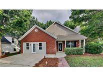 Charming single-story home featuring a brick facade, attached garage, and a welcoming front porch at 700 Patriots Point St, Locust Grove, GA 30248