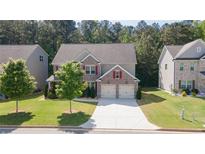 Charming two-story home featuring a well-manicured lawn, attached two car garage, and brick accents at 126 Oakleigh Pointe Dr, Dallas, GA 30157
