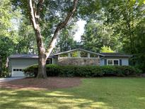 Charming one-story home with stone accents and a well-maintained lawn with mature shade trees at 1260 Willeo Creek Dr, Roswell, GA 30075