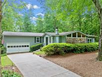 Charming one-story home with a long drive, mature trees, and stone accents at 1260 Willeo Creek Dr, Roswell, GA 30075