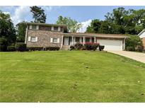 Charming brick home with a well-manicured lawn and inviting curb appeal at 3662 Greentree Farms Dr, Decatur, GA 30034
