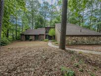 Charming home featuring stone accents and wooded surroundings at 3835 Shawnee Sw Run, Lilburn, GA 30047