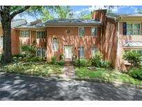 Charming brick two-story townhouse with a well-manicured lawn and walkway leading to the front entrance at 40 Ivy Chase Ne, Atlanta, GA 30342