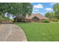 Stunning brick home with a well-manicured lawn and mature trees, offering classic charm at 5950 Meadow Brook Ln, Cumming, GA 30040