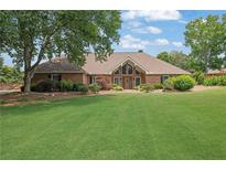 Sprawling brick home with an expansive lawn and mature trees offering a tranquil setting at 5950 Meadow Brook Ln, Cumming, GA 30040