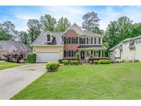 Traditional two-story home featuring brick and siding, black shutters, covered front porch, and a lush, green lawn at 1265 Kelly Nelson Dr, Lawrenceville, GA 30043