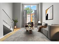 Bright living room featuring a modern staircase, large window, and contemporary decor at 1271 Ponti Nw Mews # 92, Atlanta, GA 30318