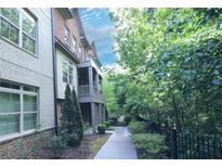 Charming brick townhome featuring lush landscaping and a quaint covered front porch at 116 Festoon Ct, Smyrna, GA 30080