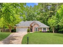 Charming brick home featuring a manicured lawn, two-car garage and a beautifully landscaped front yard at 5850 Shannon Dr, Cumming, GA 30040
