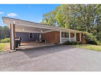 Single story brick home featuring a carport and white porch railing at 1646 Highway 92 N, Fayetteville, GA 30214