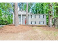 Charming gray brick home featuring a bright red front door and classic white pillar accents at 2922 Carriage Ln, Atlanta, GA 30349