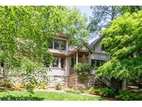 Charming two-story home featuring a stone foundation, manicured lawn, and lush landscaping at 138 Garland Ave, Decatur, GA 30030